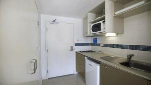 a kitchen with a sink and a microwave at Allure in Ettalong Beach