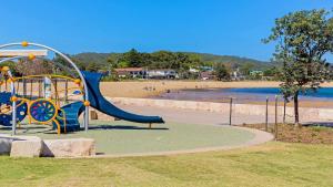 a playground in a park next to a beach at Allure in Ettalong Beach +1 photo