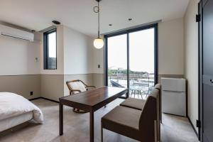 a bedroom with a desk and a bed and a window at Cottage TAIZA in Kyotango