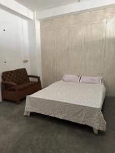 un dormitorio con una cama y una silla en W-26 Dawrpui, en Āīzawl 8 fotos más
