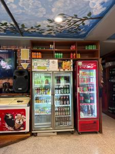 a store with two refrigerators and a tv in a room at Rungrueng Apartment in Amphoe Koh Samui