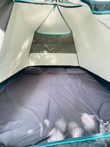 una tienda de campaña abierta con un colchón morado dentro en EarthWise Camping, en Kalpetta