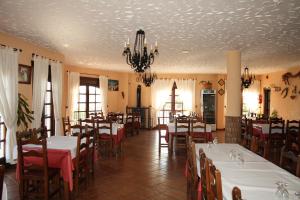 a dining room with tables and chairs and a chandelier at Hotel Restaurante Atalaya in Comares