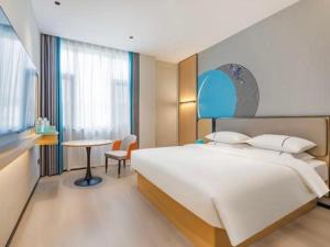 une chambre avec un grand lit blanc et une table dans l'établissement City Comfort Inn Huanggang Tuanfeng Passenger, à Luotian 190 autres photos