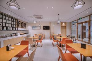 a restaurant with tables and chairs and a kitchen at City Comfort Inn Nanning Yudong Jinxiang Metro Station in Nanning
