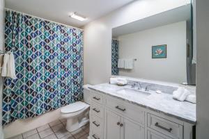 a bathroom with a sink and a toilet and a shower at Sandpiper #108 in Tybee Island +18 photos