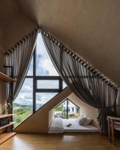 a bed in a room with a large window at Là Yên Retreat in Ấp Ða Lợi +142 photos