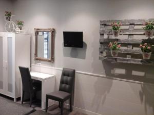 una sala d'attesa con scrivania e TV a parete di Hostal Don Alfonso a Madrid Altre 37 foto