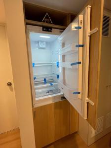 an empty refrigerator with its door open in a room at Apartamento Amoblado a un paso del parque de las aguas in Lima