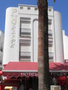 a hotel with a palm tree in front of a building at Pensión Felipe in Carboneras