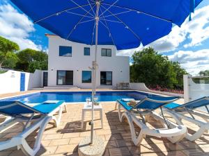 una villa con piscina y una sombrilla azul en Casa O Sonho near Faro with private pool, en Santa Bárbara de Nexe