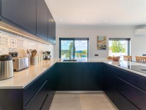 Una cocina con gabinetes negros y encimera. en Casa O Sonho near Faro with private pool, en Santa Bárbara de Nexe