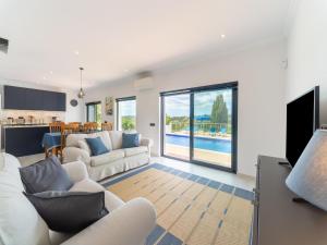 sala de estar con muebles blancos y piscina en Casa O Sonho near Faro with private pool, en Santa Bárbara de Nexe