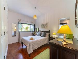 Un dormitorio con una cama y una mesa con una lámpara. en Casa O Sonho near Faro with private pool, en Santa Bárbara de Nexe 32 fotos más