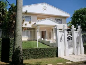ein weißer Zaun vor einem Haus in der Unterkunft Pousada Flat Mobiliado com 70 m2 de Área Privativa com o máximo conforto in Atibaia