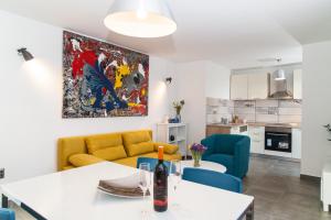 un soggiorno con divano giallo e sedie blu di Apartment Ema a Rogoznica (Rogosnizza)