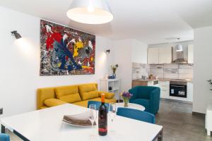 a living room with a yellow couch and blue chairs at Apartment Ema in Rogoznica