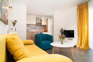 un soggiorno con divano giallo e tavolo di Apartment Ema a Rogoznica (Rogosnizza)