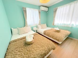 two beds in a room with blue walls and windows at THE FEEL ONNA 2 / Vacation STAY 18771 in Onna