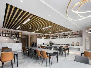 un ristorante con tavoli e sedie e un bar di GEM Hotel Changzhou Xuejia'aoyuan North High-Speed Railway Station a Changzhou
