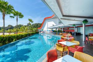 a resort with a swimming pool with tables and chairs at Lexis Hibiscus Port Dickson in Port Dickson