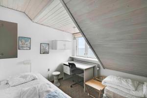 a bedroom with two beds and a desk and a window at Spacious House With Sea Views From All Rooms in Rønne