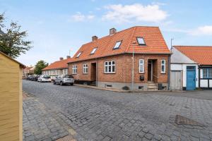 a brick house with an orange roof on a street at Spacious House With Sea Views From All Rooms in Rønne