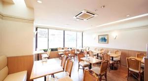 a restaurant with tables and chairs in a room at Inuyama Central Hotel in Inuyama