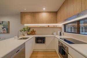 a kitchen with white counters and wooden cabinets at Charming Getaway on Gloucester Street in Linwood