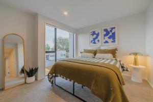 a bedroom with a bed and a large window at Charming Getaway on Gloucester Street in Linwood