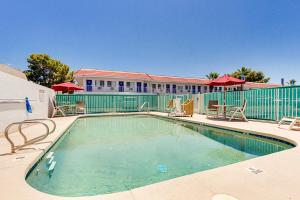 a swimming pool with chairs and a building at Motel 6-Tempe, AZ - Scottsdale South in Tempe