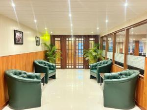 a waiting room with green chairs and plants at Mount Thistle Boutique Hotel in Darjeeling