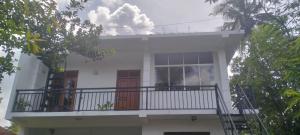 une maison blanche avec un balcon et une cheminée dans l'établissement Rose Apartment, à Kadawata 3 autres photos