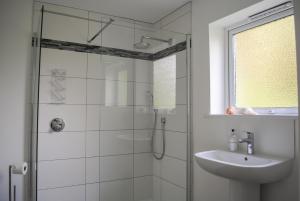 a white bathroom with a shower and a sink at Dolphins in Salcombe +32 photos