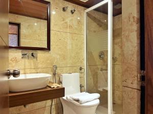 a bathroom with a toilet and a sink and a shower at Mount Thistle Boutique Hotel in Darjeeling +11 photos