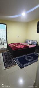 a bedroom with a bed and two rugs on the floor at SAI Guest House at Gangtok Taxi Stand in Gangtok +38 photos