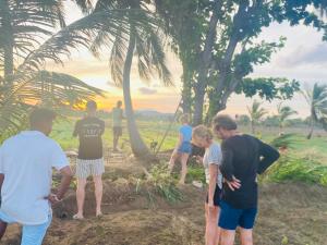 a group of people standing around under palm trees at Hotel A one - Kalawewa in Hungawila