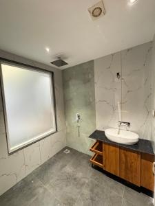 a bathroom with a sink and a large window at Nazaara Hills Retreat in Thūr