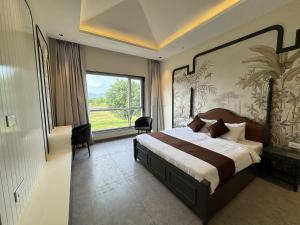 a bedroom with a large bed and a large window at Nazaara Hills Retreat in Thūr