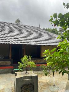 a building with a fireplace in front of it at Aravanazhi tharavadu in Thirunelli