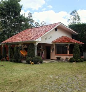 a small house with a red roof at Casa de campo La Valentina - CUENCA in Azogues