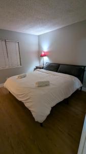 シミバレーにあるSerene home in Simi valley, CAのランプ付きの客室内の大きな白いベッド