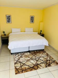 a bedroom with a large bed in a yellow wall at Cozy 2 Bedroom near Kruger in Hectorspruit