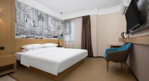 a hotel room with a white bed and a television at City Comfort Inn Wuhan Huanghe Tower Shouyi Metro Station in Wuhan