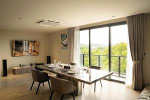 a dining room with a table and chairs and a large window at Richmann Resort Hotel Hatyai in Hat Yai