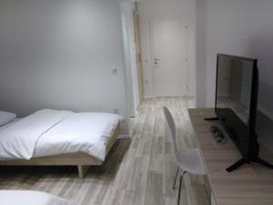 a bedroom with a bed and a chair and a television at Svadbeni salon STEFAN in Nevesinje