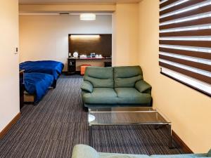 a living room with a couch and a bed at ホテルマリンピア in Enokizu