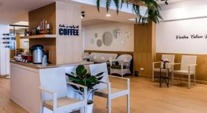 a salon with white chairs and a counter and a table at Magic House Hostel in Hua Hin