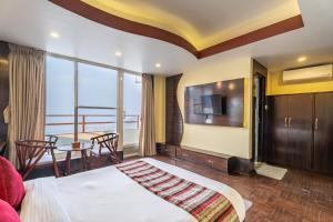 - une chambre avec un lit et une table avec vue dans l'établissement Village Highland Resort, à Godāvari