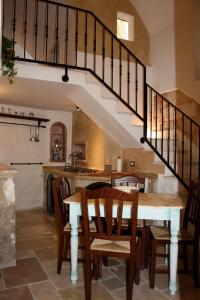 a kitchen and dining room with a table and stairs at Corte Del Campanaro in Ugento